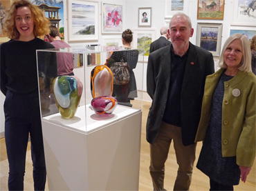 Thumbnail image of Alice Heaton with her prize-winning glass pieces and Marck Geary and Gillian Geary of Student Award sponsors West End Gallery - Preview Evening: LSA Annual Exhibition 2016