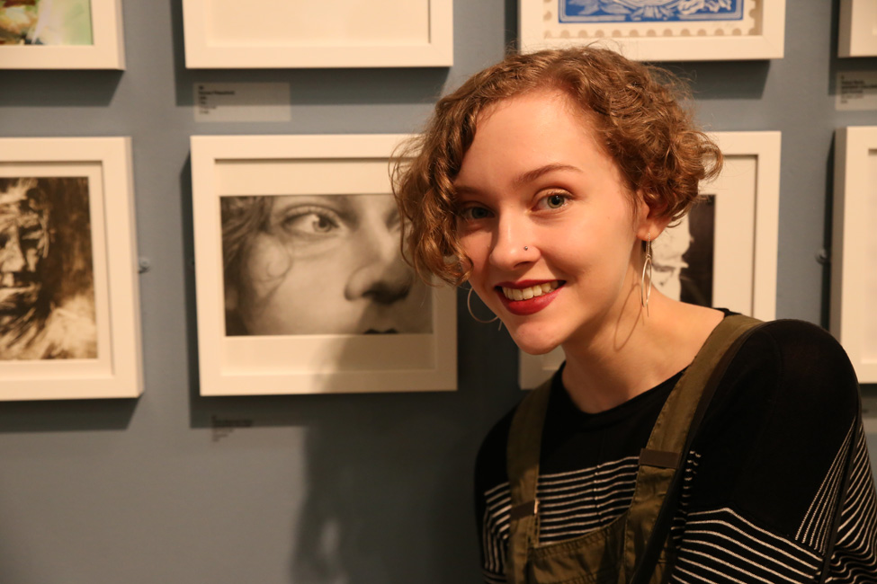 Thumbnail image of Orlan Sharman-Dunn, Leicester College student, in front of her self portrait - Little Selves - Preview Photographs